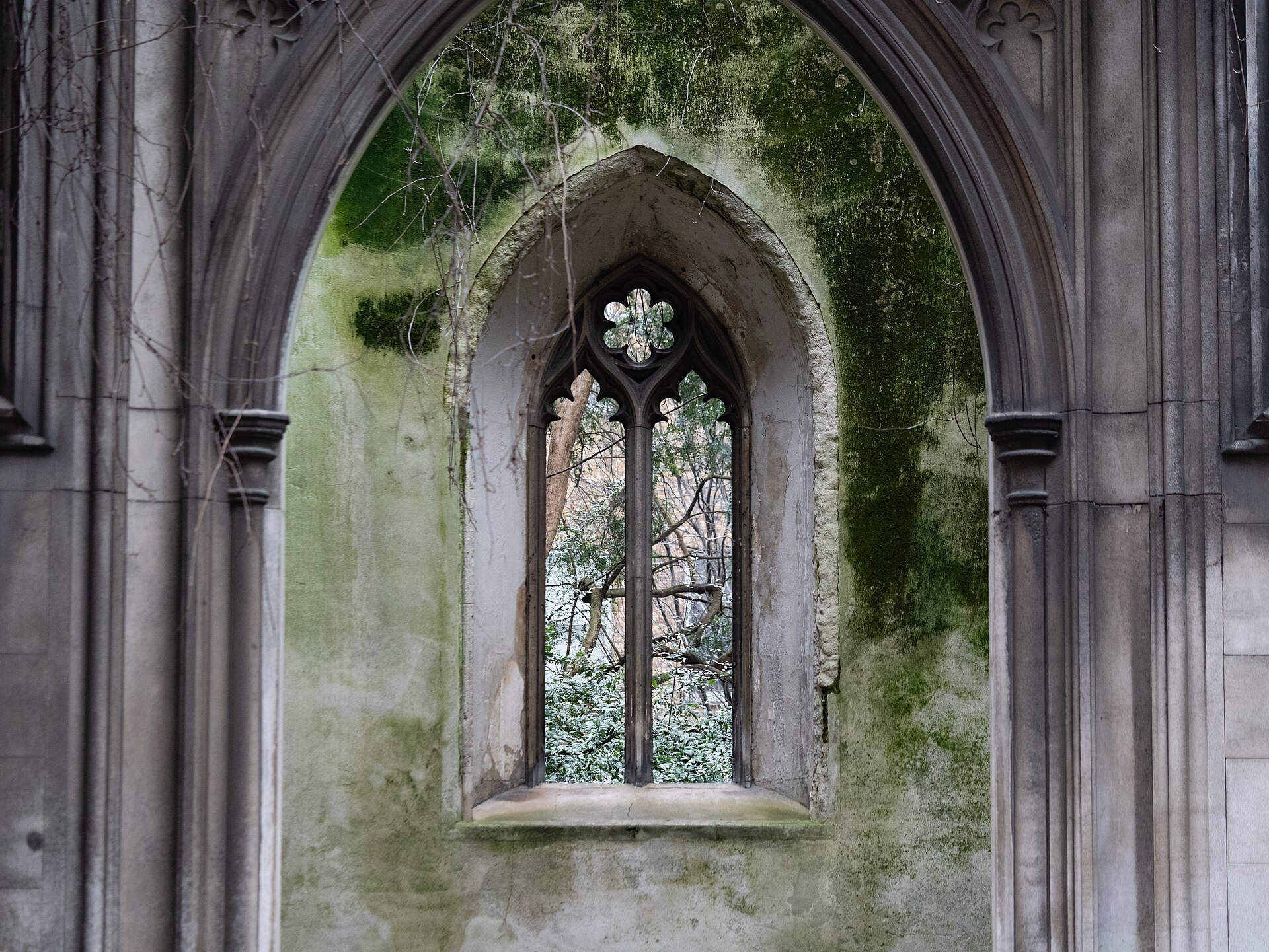 Moss-covered Gothic arch of the ruined St Dunstan in the East church garden, London