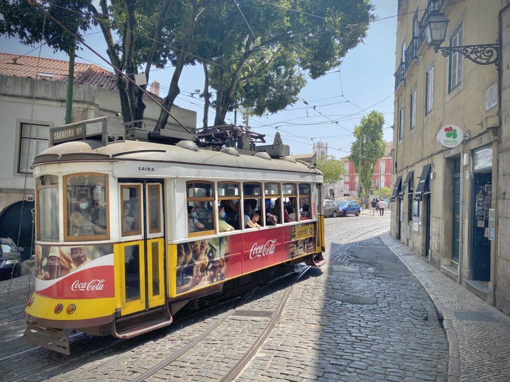 Yellow vintage tram on a narrow street in Alfama, Lisbon