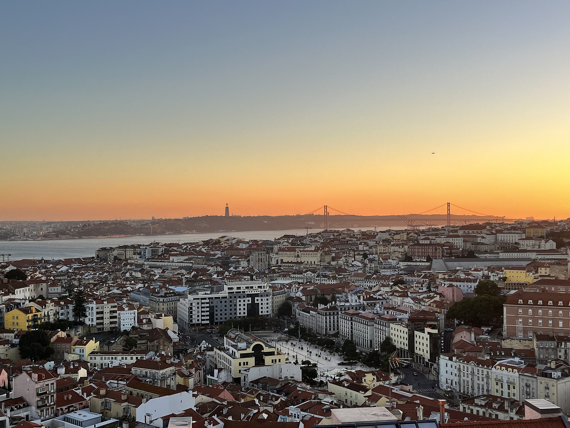 Sunset over Lisbon's Alfama rooftops and the Tagus River from Miradouro da Graça