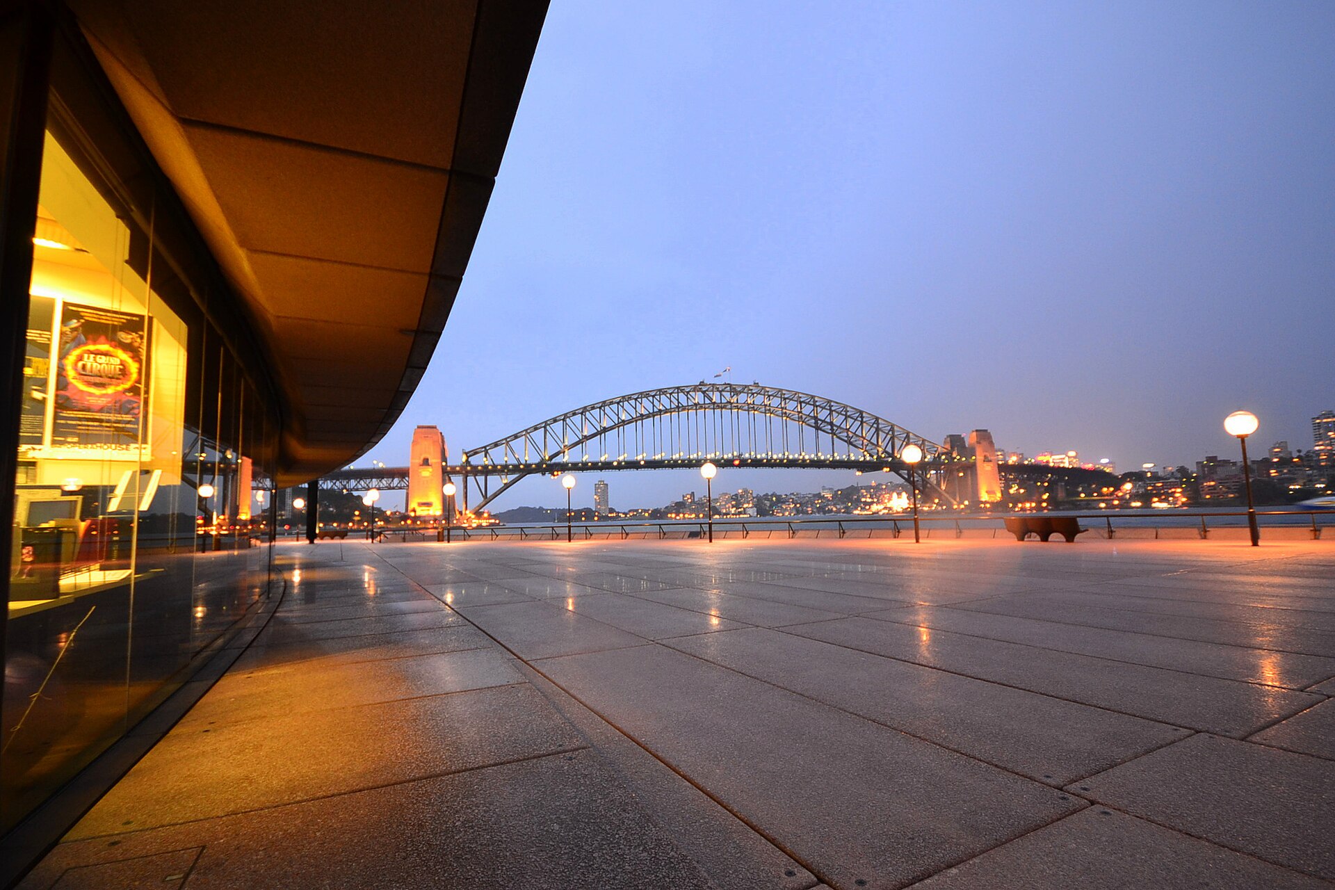 Sydney Opera House forecourt at dusk with the Harbour Bridge