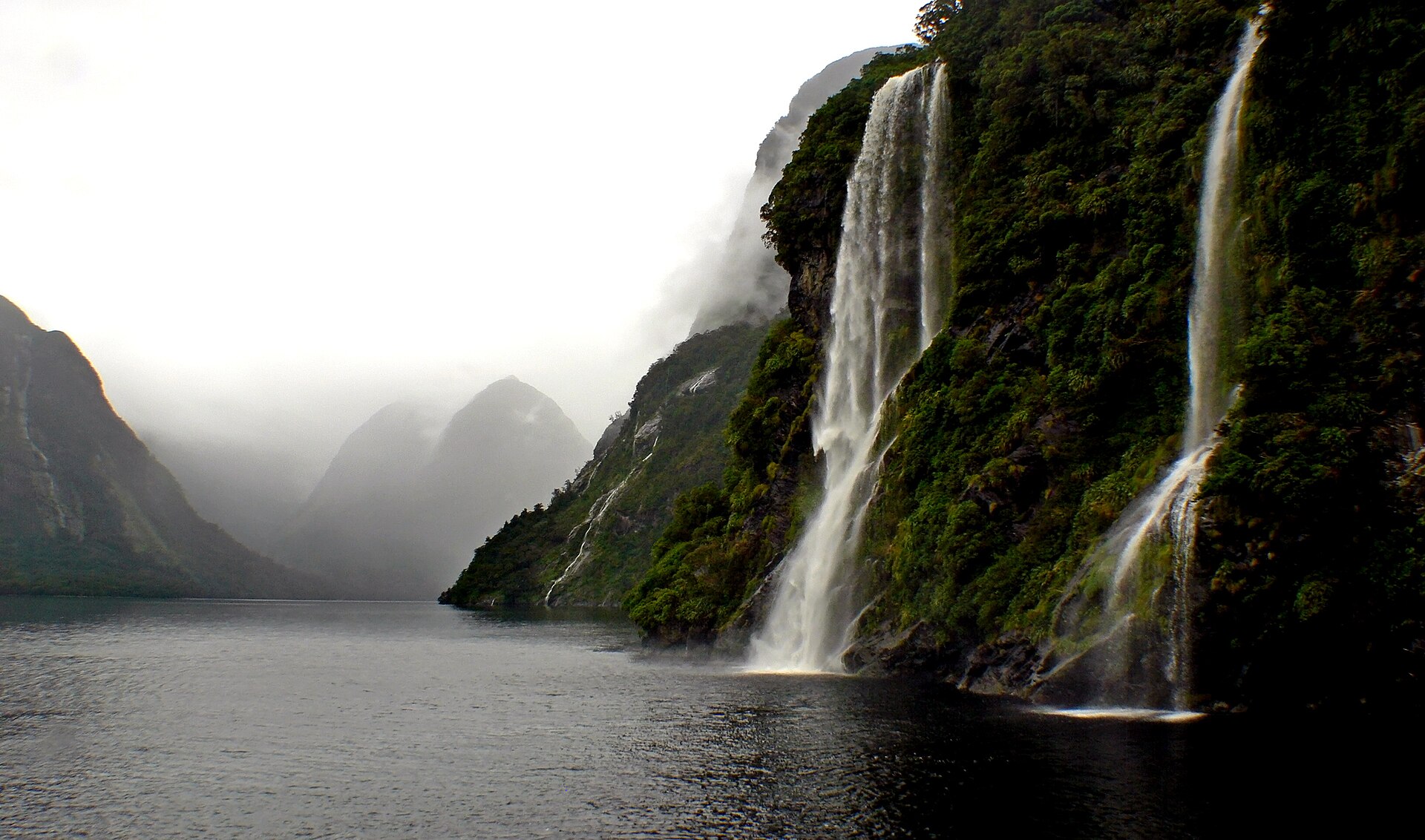 Doubtful Sound's forested fiord walls under a dramatic sky, Fiordland, New Zealand