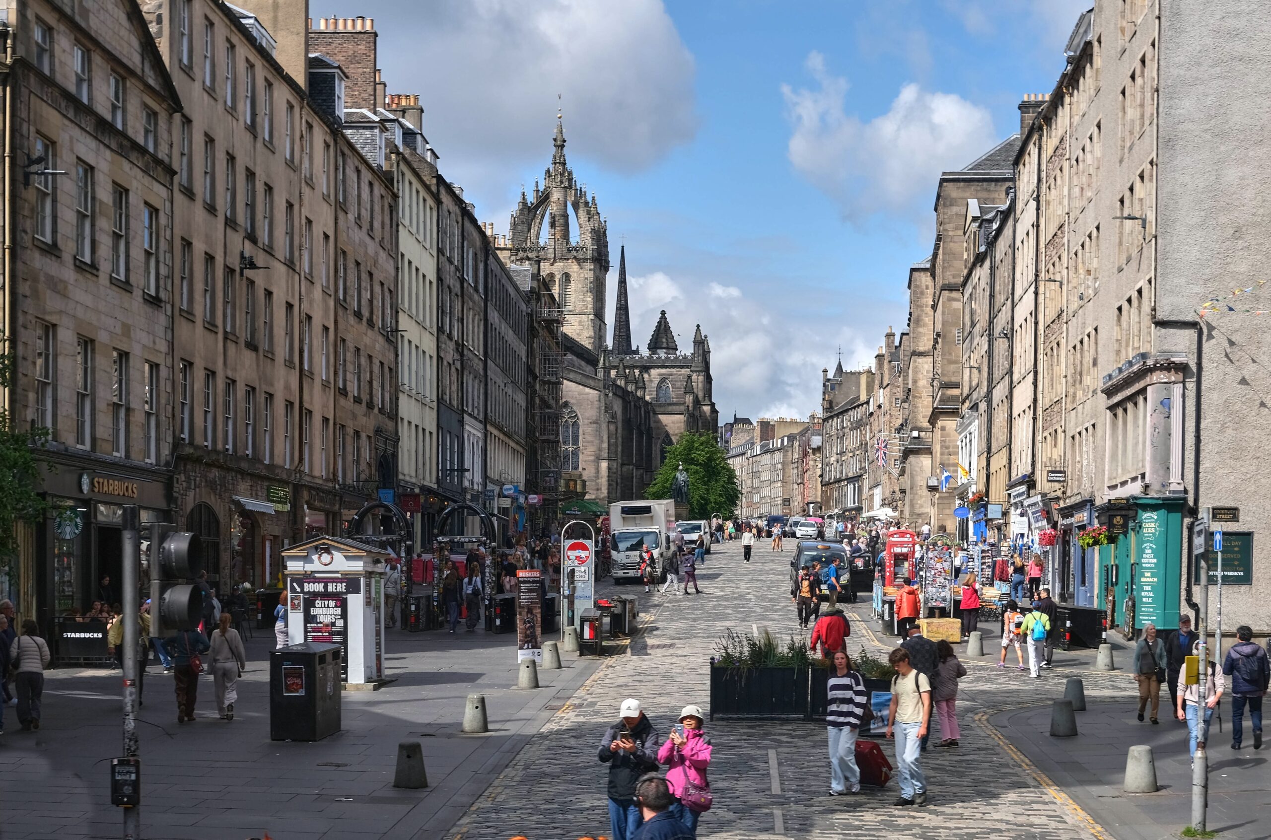 Busy Royal Mile street scene with historic tenements and St Giles' Cathedral spire in Edinburgh