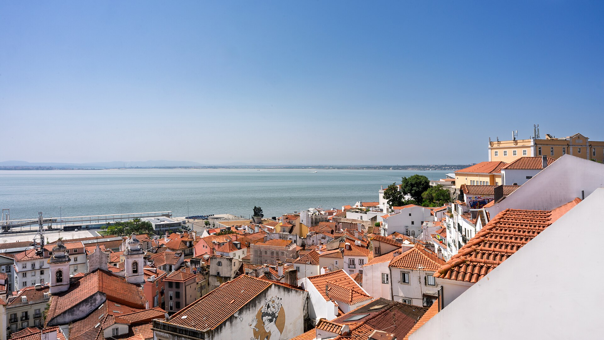 Terracotta rooftops of Alfama with the Tagus River beyond