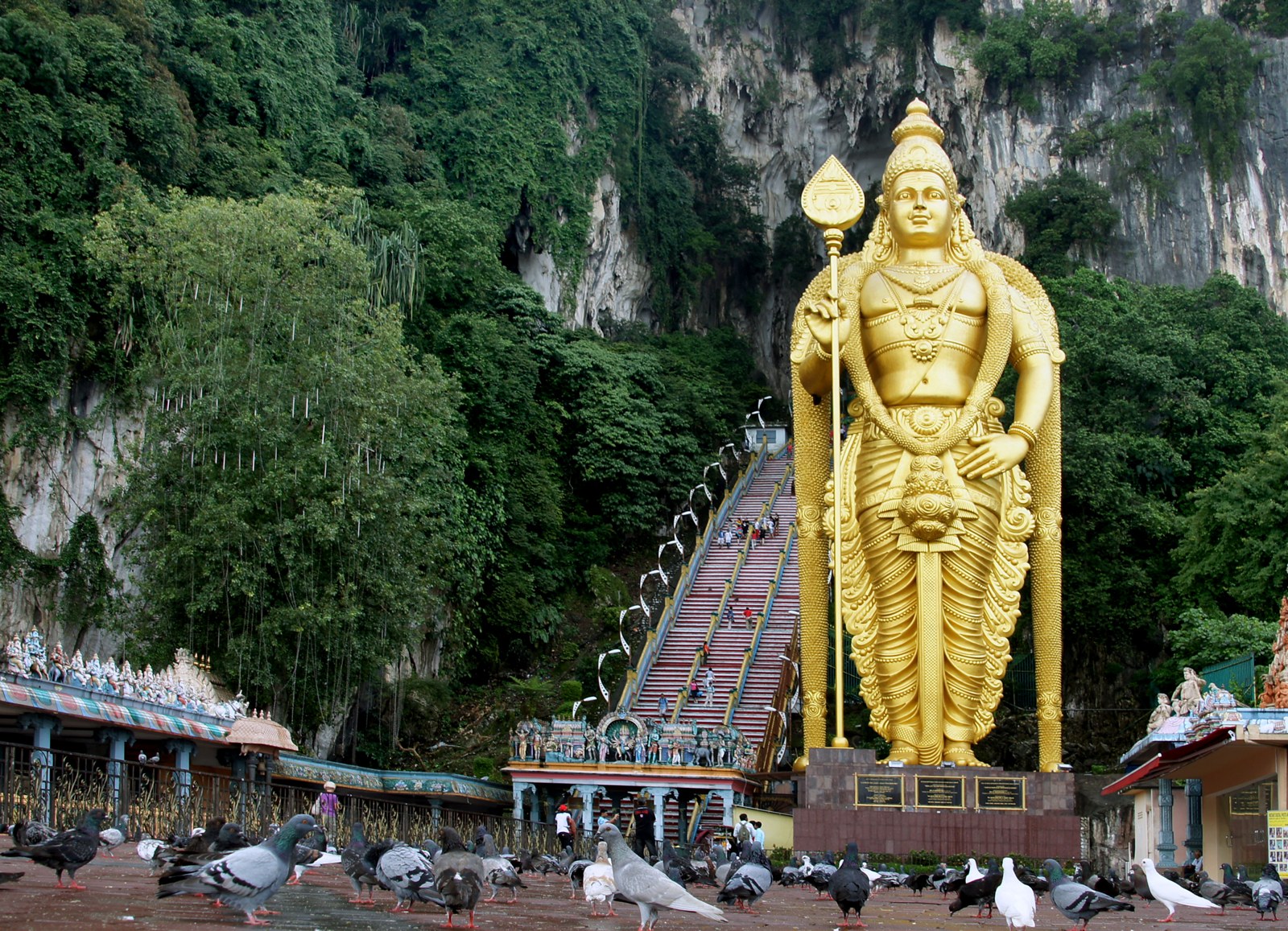 Batu Caves entrance Kuala Lumpur with the gold Lord Murugan statue and limestone hill