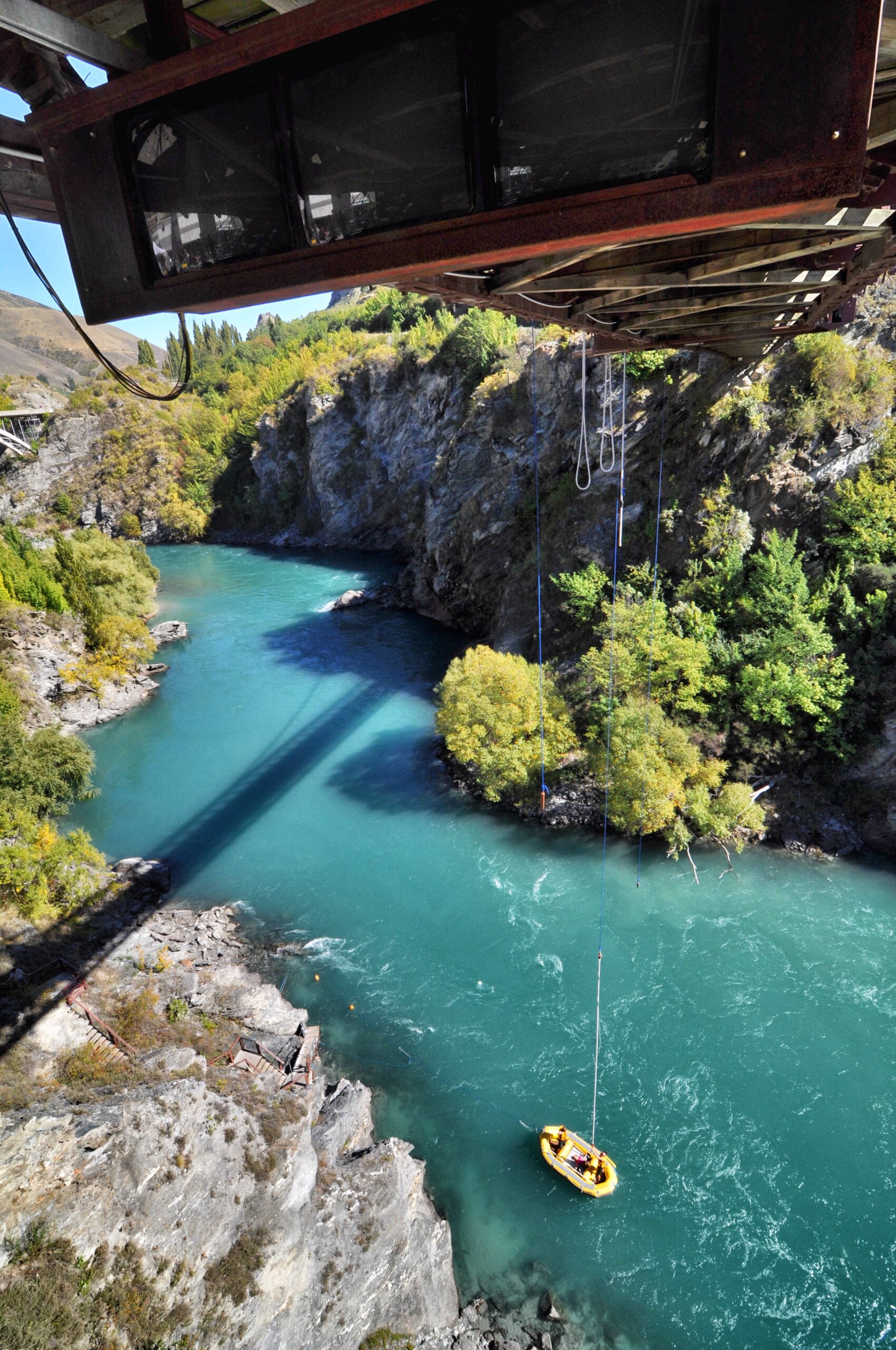 Kawarau Bridge bungy jump — a jumper mid-drop over the turquoise Kawarau River near Queenstown