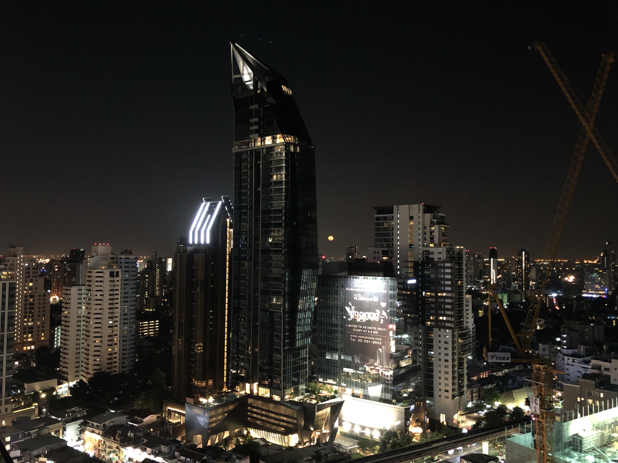 Sukhumvit Road in Bangkok lit up at night with traffic and neon signs