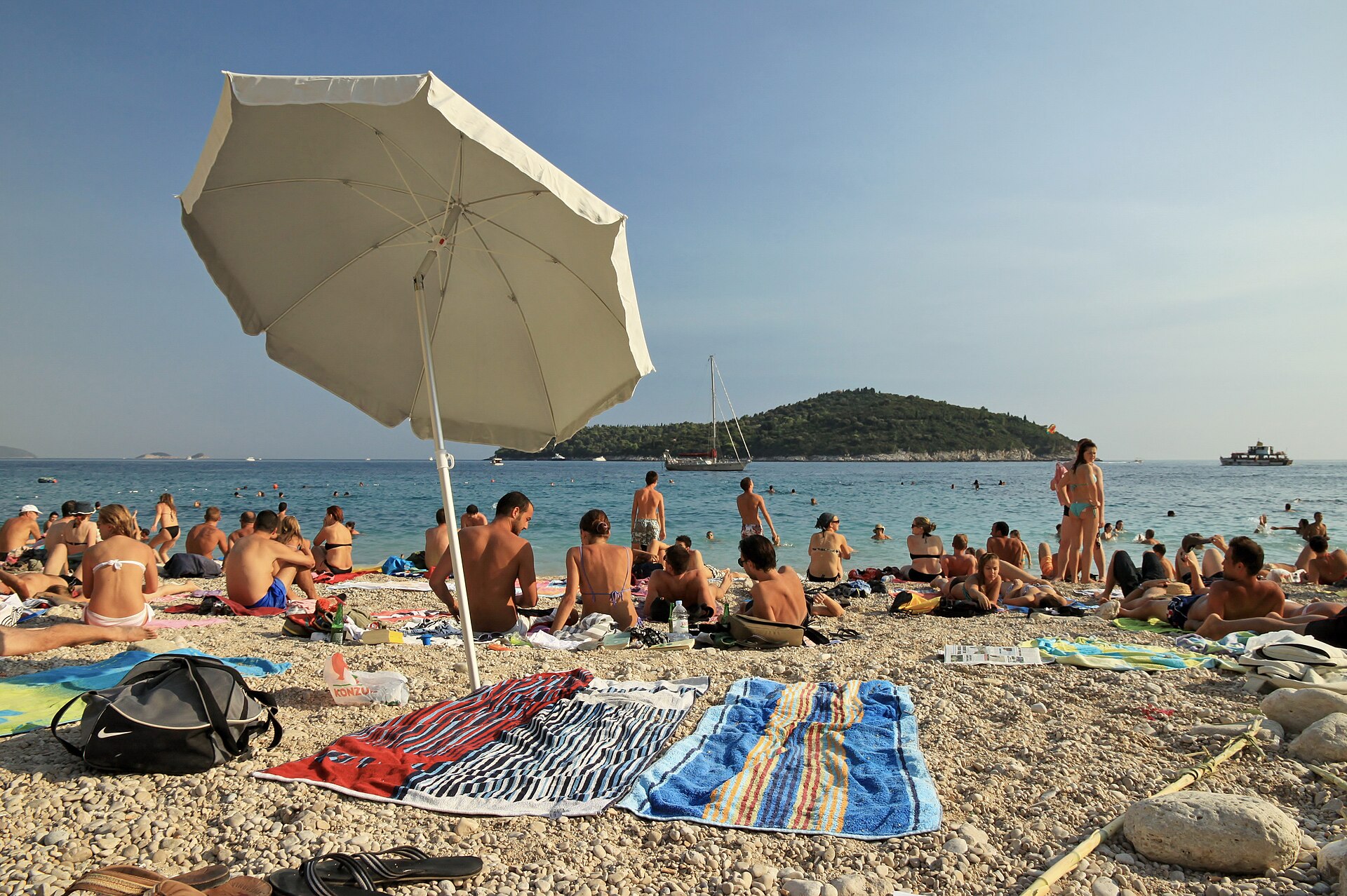 Sunbathers and swimmers crowding Banje Beach below Dubrovnik's Old Town