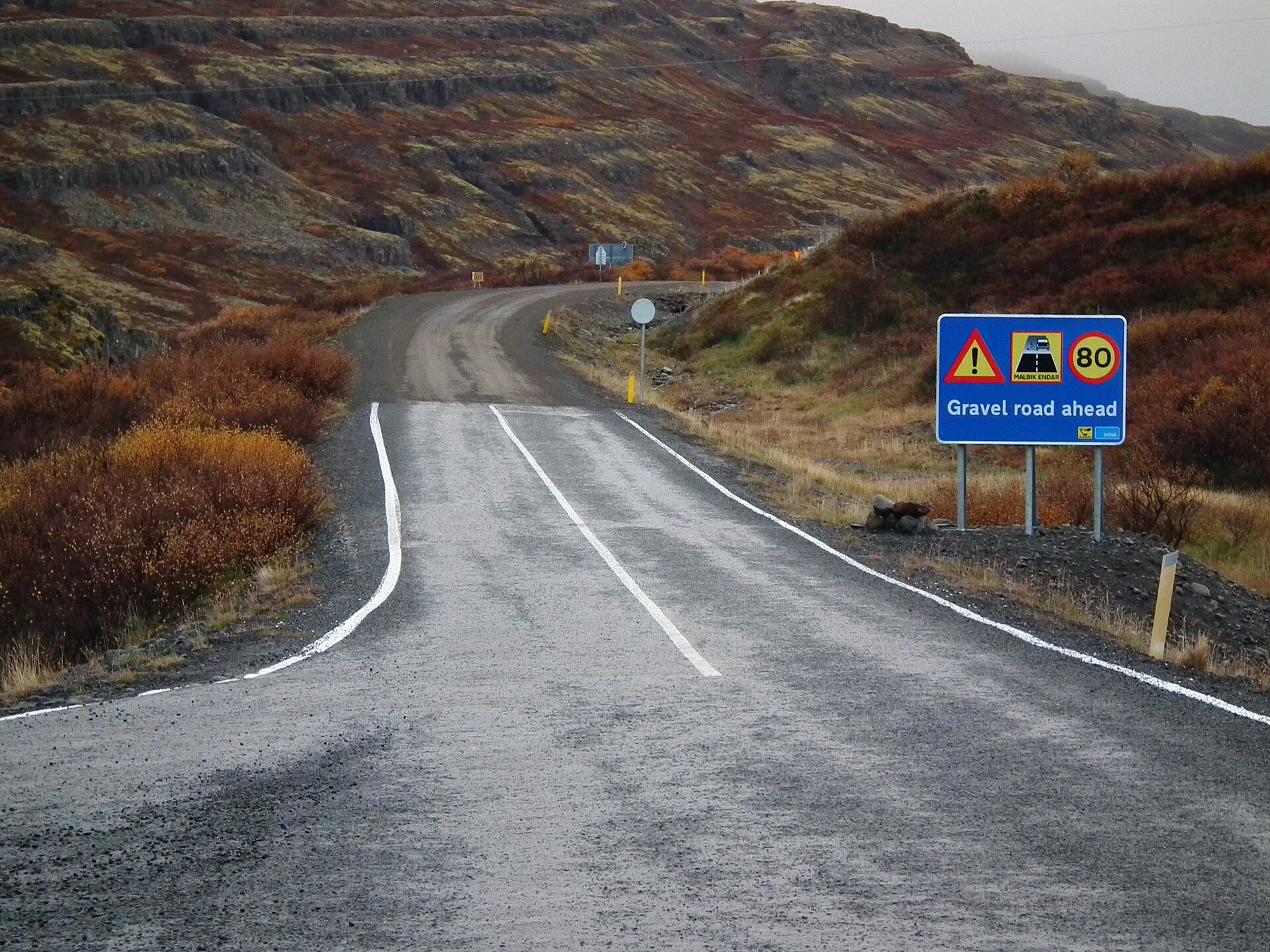 Icelandic warning sign for a gravel road ahead on Road 60
