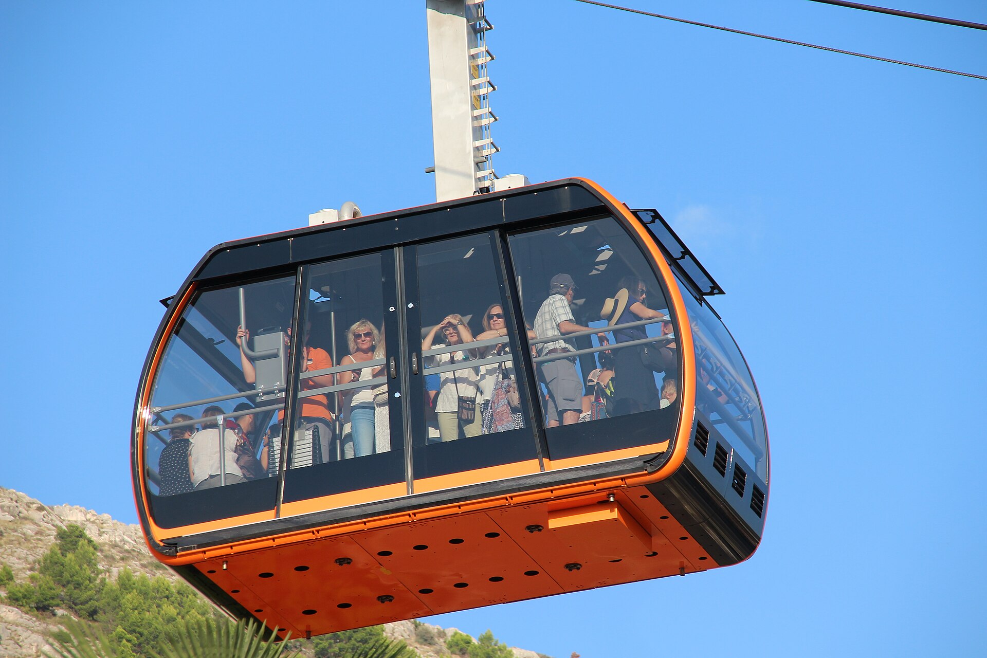 A cable car gondola carrying passengers up to Mount Srđ above Dubrovnik