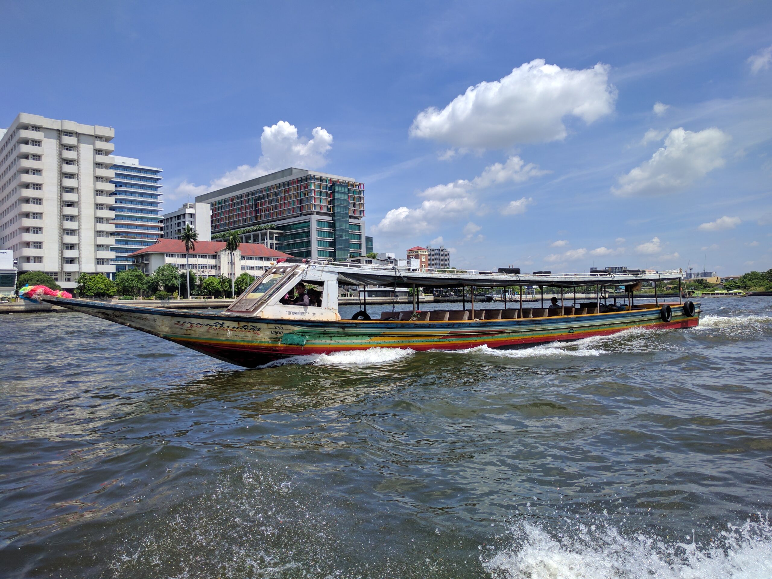 A long-tail boat moving along the Chao Phraya River in Bangkok