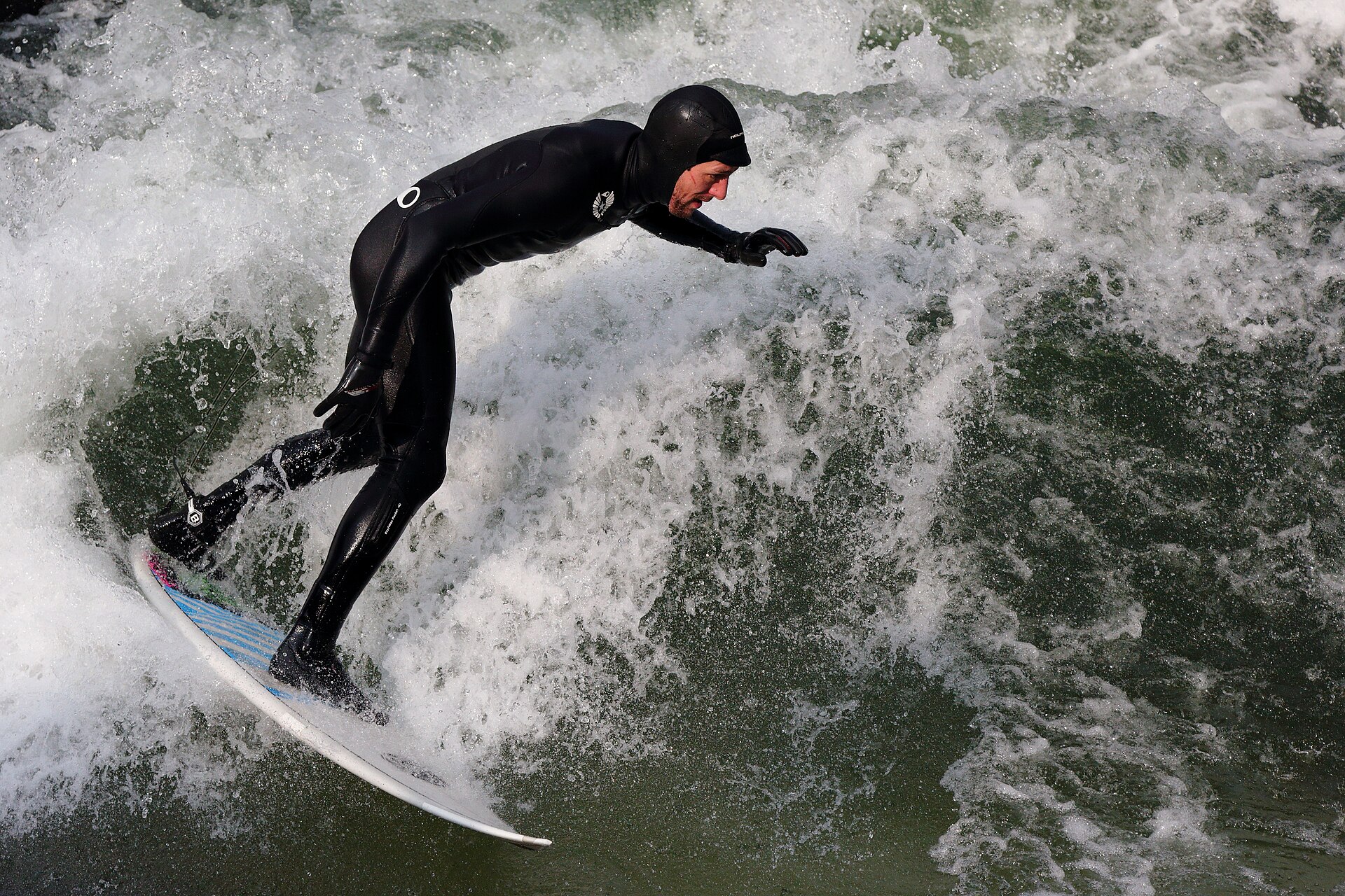 A surfer riding the Eisbach standing wave in Munich's English Garden