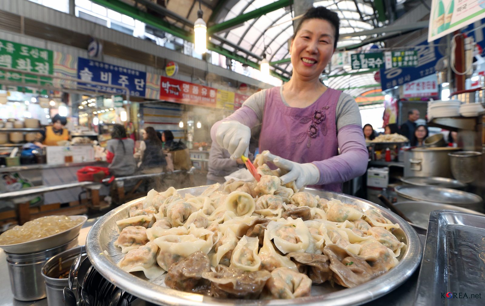 Diners eating Korean street food at stalls inside Gwangjang Market in Seoul