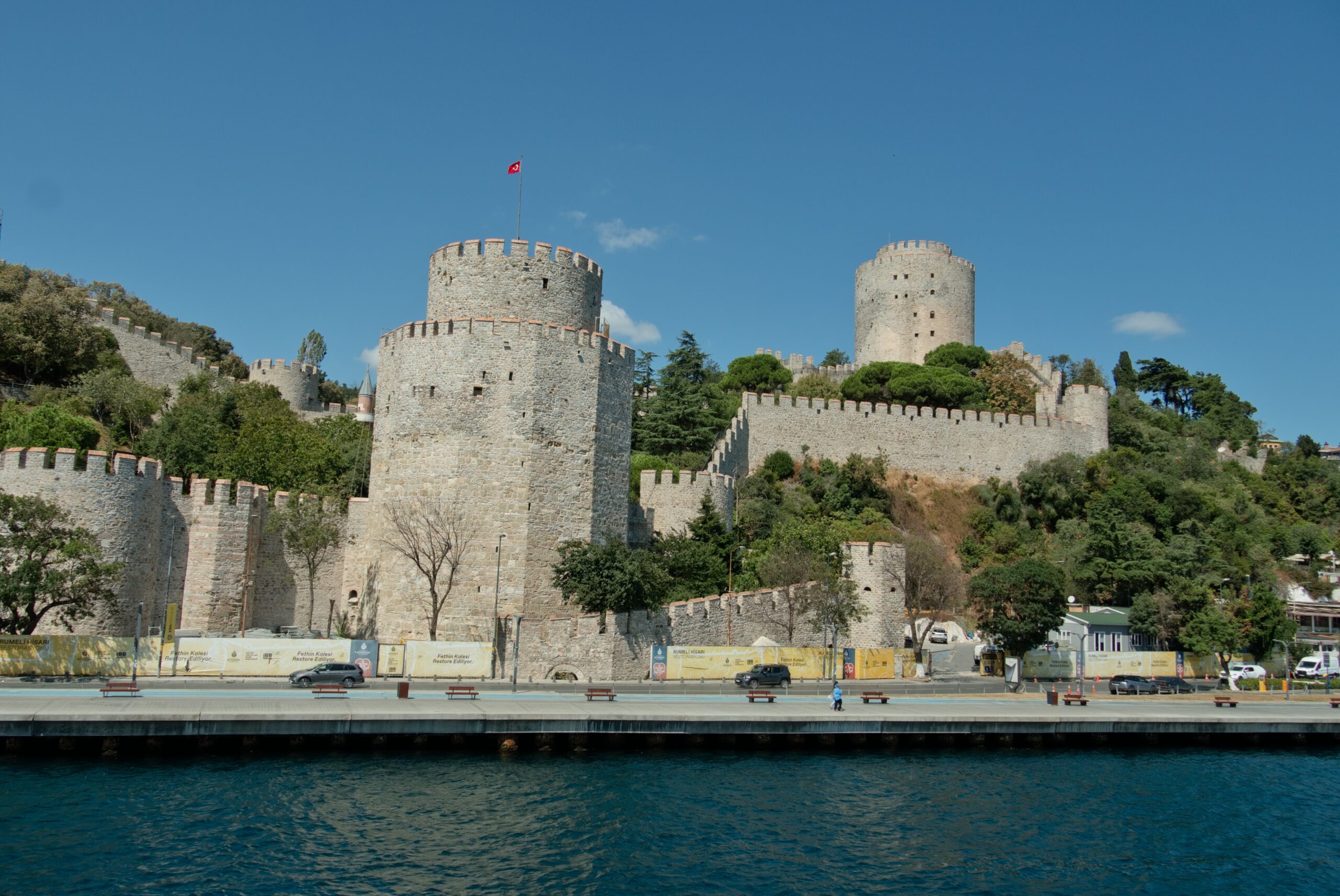 The stone towers and crenellated walls of Rumeli Fortress rising above the Bosphorus strait.