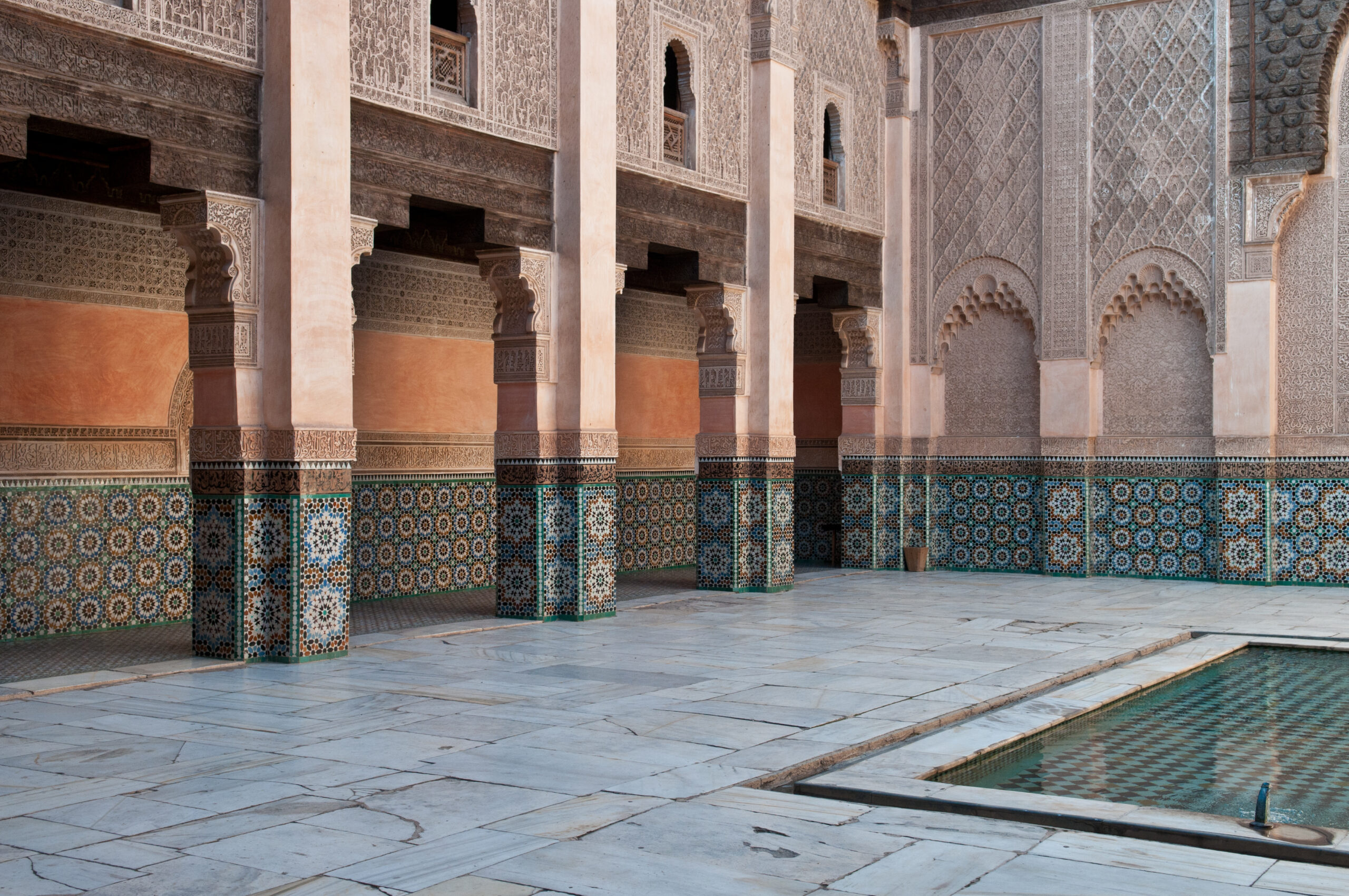 The carved and tiled courtyard of Ben Youssef Madrasa with its central marble pool.