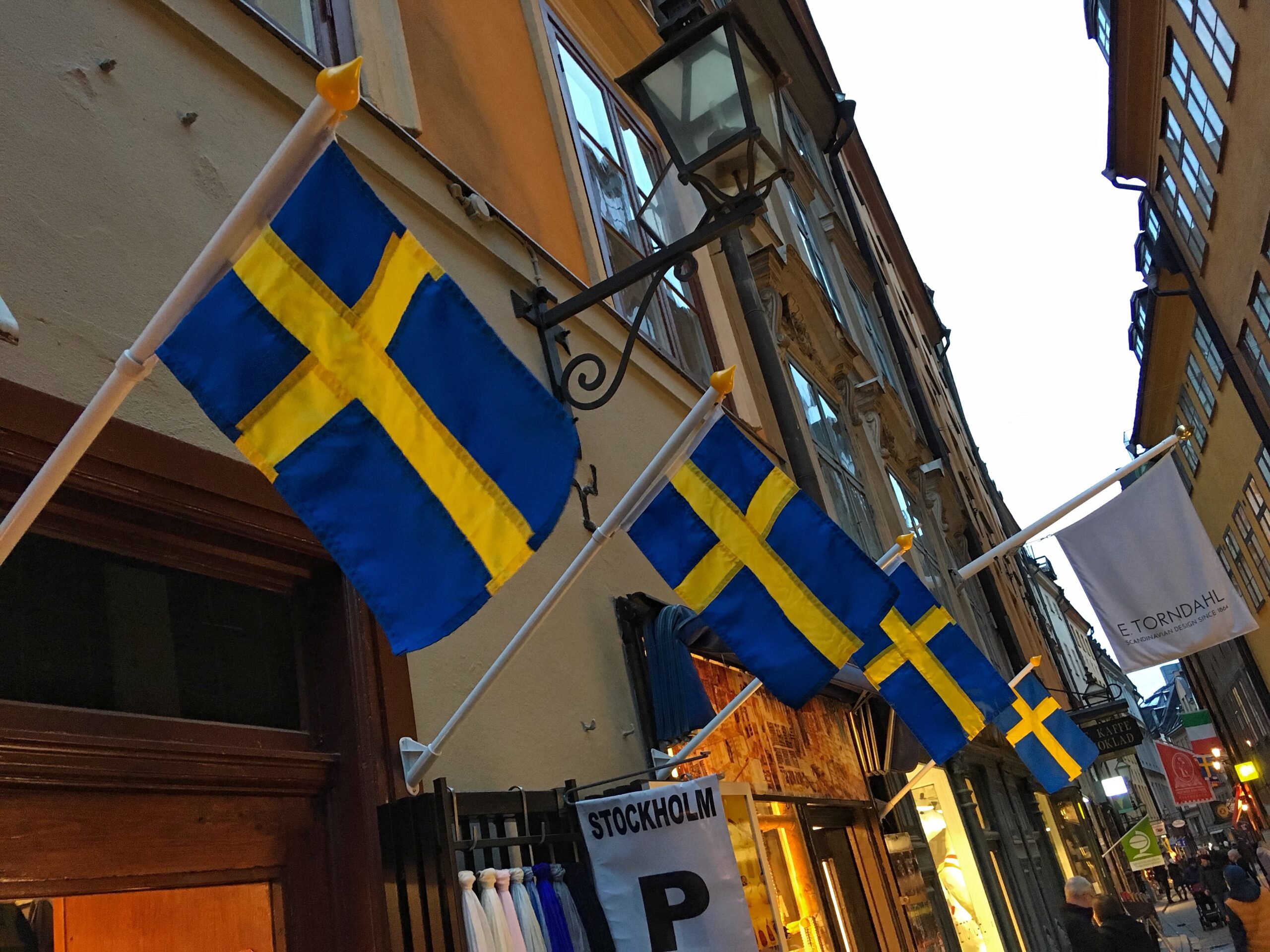 Stockholm Old Town Gamla Stan cobblestone street with Swedish flags in Sweden