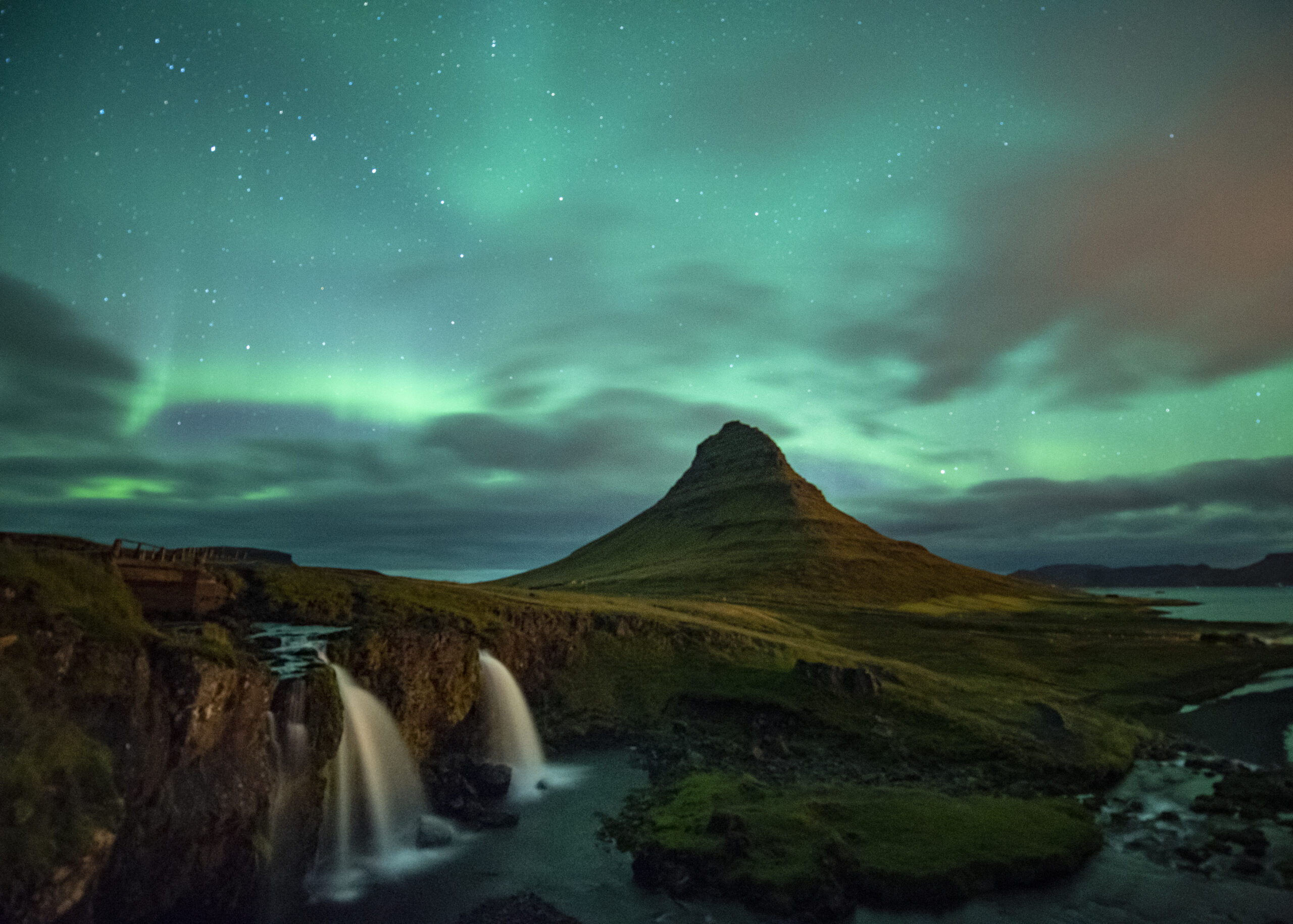 Northern lights over Kirkjufell mountain and waterfall in Iceland