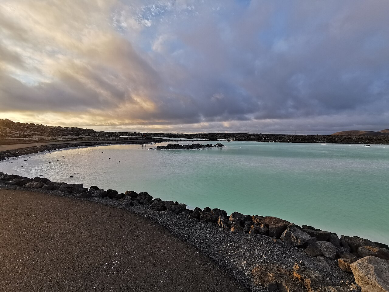 The milky-blue water of the Blue Lagoon in its black lava field