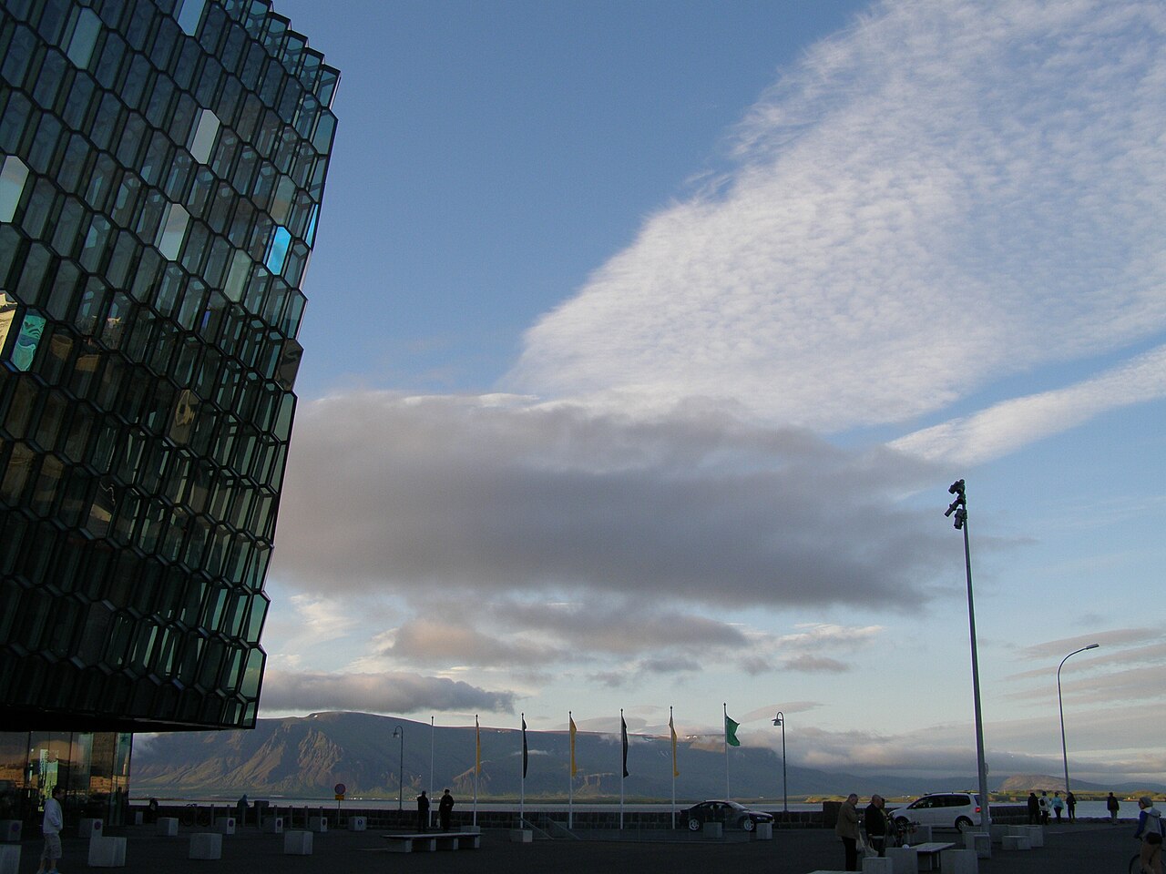 Harpa concert hall's glass facade in Reykjavik with mountains across the bay