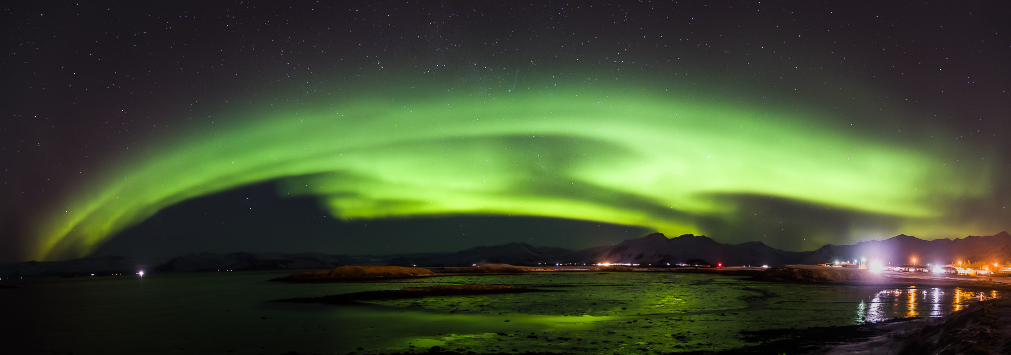 Aurora borealis over water near Hofn, southeast Iceland