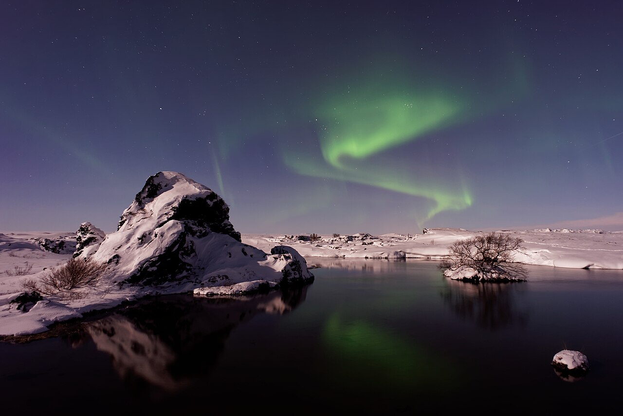 Northern lights dancing over a snowy lake in Iceland